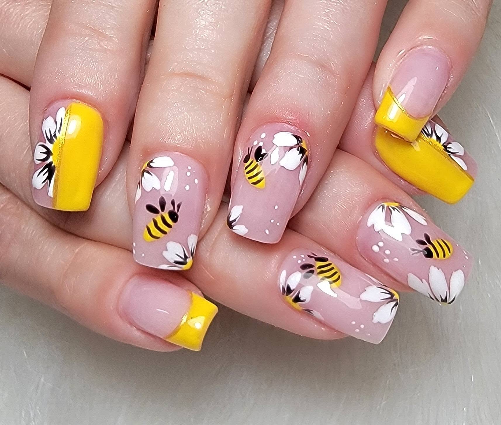 Yellow French tips with hand-painted daisies and tiny bees