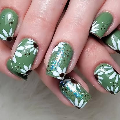 Sage green botanical manicure with white leaves and glitter